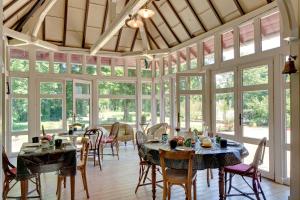 un comedor con mesas, sillas y ventanas en Le Monde de Charlie, en Vichy