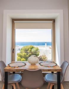 a dining room table with a view of the ocean at Porto Bello Tinos in Agios Ioannis