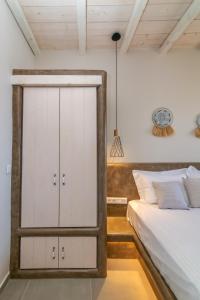 a bedroom with a white cabinet next to a bed at Porto Bello Tinos in Agios Ioannis