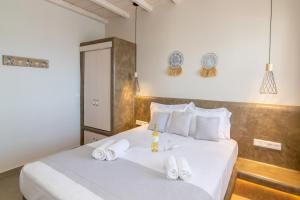 a bedroom with two beds with white towels on them at Porto Bello Tinos in Agios Ioannis