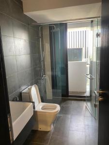 a bathroom with a toilet and a sink and a shower at Almas Suite in Nusajaya