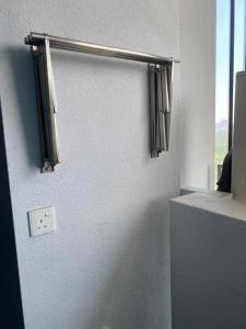 Zimmer mit einem Fenster mit Vorhängen an der Wand in der Unterkunft Almas Suite in Nusajaya