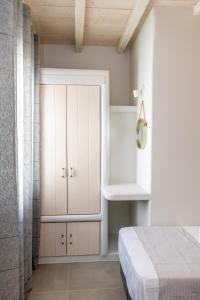 a bedroom with a white cabinet and a bed at Porto Bello Tinos in Agios Ioannis