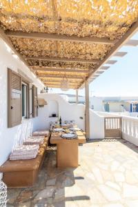 een patio met een tafel en stoelen op een dak bij Porto Bello Tinos in Agios Ioannis