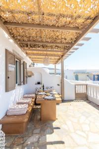a patio with a table and chairs on a roof at Porto Bello Tinos in Agios Ioannis