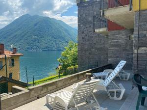 a balcony with chairs and a view of a lake at Appartamenti vista lago in Argegno