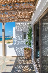 een patio met een potplant en uitzicht op de oceaan bij Porto Bello Tinos in Agios Ioannis