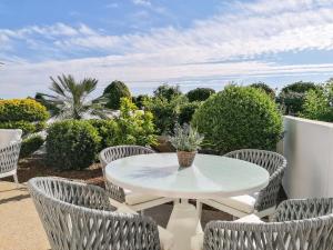 a patio with a white table and chairs at Atlantis Gardens in Mazotos
