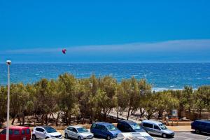 a kite flying over a parking lot next to the ocean at MEDANO4YOU Cabezo at Marineda in El Médano