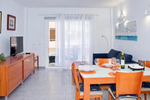 a dining room and living room with a table and chairs at MEDANO4YOU Cabezo at Marineda in El Médano +21 photos