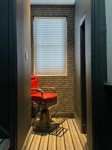 un pasillo con una silla roja y una ventana en The Lazy Pug en Shipston on Stour