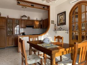 a kitchen with a wooden table and wooden cabinets at Casa di Rosaria - Due appartamenti nel centro storico con giardino sul terrazzo in Depressa