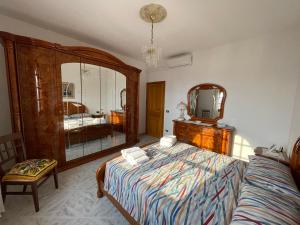 a bedroom with a bed and a mirror at Casa di Rosaria - Due appartamenti nel centro storico con giardino sul terrazzo in Depressa
