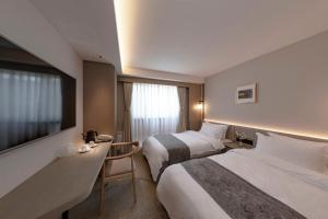 a hotel room with two beds and a flat screen tv at Yukari no Mori in Fujikawaguchiko +30 photos