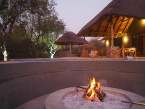 a fire pit in a backyard with a house at Pata Pata House in Marloth Park