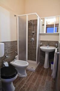 a bathroom with a shower and a toilet and a sink at Madema B&B in Cefalù