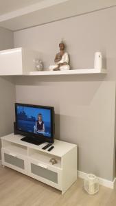 una sala de estar con TV en un centro de entretenimiento blanco en Apartment Pontus Stellae, en Santiago de Compostela