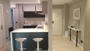 una cocina con barra y dos taburetes. en Apartment Pontus Stellae, en Santiago de Compostela