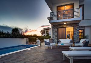 une maison avec une terrasse et une piscine dans l'établissement Atlantis Gardens, à Mazotos