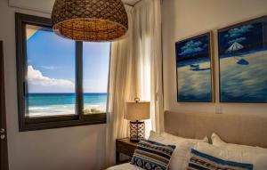 una camera da letto con finestra affacciata sull'oceano di Atlantis Gardens a Mazotos