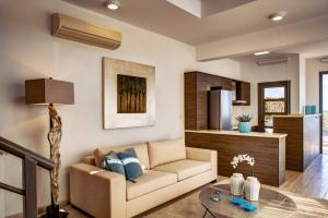 a living room with a couch and a table at Atlantis Gardens in Mazotos