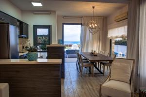 a kitchen and dining room with a table and chairs at Atlantis Gardens in Mazotos