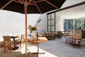 a restaurant with tables and chairs and an umbrella at FONDATION CAB St-Paul-de-Vence in Saint Paul de Vence