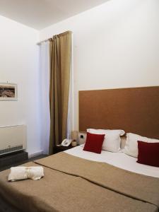 カターニアにあるホテル ヴァレンティノのベッドルーム1室(大型ベッド1台、赤と白の枕付)