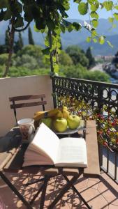 an open book on a table with a plate of fruit at Apartman Anja in Budva
