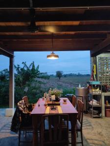 a dining room table with a view of a field at Ban Suan Khun Yai in Phra Nakhon Si Ayutthaya