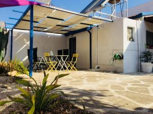 a patio with yellow chairs and a table at Artist Cottage in Dromolaxia in Larnaca