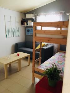 a room with a bunk bed and a table and a couch at Artist Cottage in Dromolaxia in Larnaka