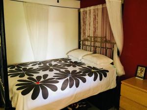 a bedroom with a bed with a black and white blanket at Artist Cottage in Dromolaxia in Larnaka +3 photos