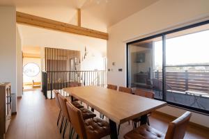 uma grande sala de jantar com mesa e cadeiras em Fuji Gran Villa - TOKI - em Fujiyoshida