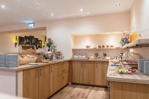 a large kitchen with wooden cabinets and counters at Hotel Altes Weinhaus in Neustadt an der Weinstraße