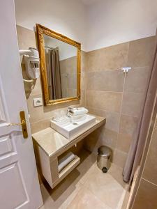 a bathroom with a sink and a mirror at Hotel Relais Du Postillon in Antibes +37 photos