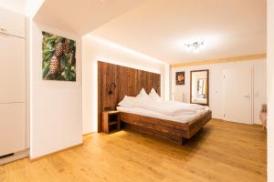 a bedroom with a bed with a wooden headboard at Landgasthof zum Schützen in Oberried