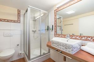 a bathroom with a shower and a sink and a toilet at Hotel Altes Weinhaus in Neustadt an der Weinstraße
