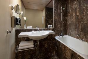 Treffen House Doha - Souq Waqif and next to Msheireb Metro Station في الدوحة: حمام مع مغسلة وحوض استحمام