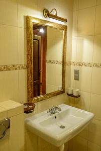 W łazience znajduje się biała umywalka i lustro. w obiekcie Karczma Regionalna Hotel GOŚCINNA CHATA w Wysowej-Zdroju