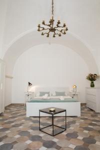 - une chambre avec un lit et un lustre dans l'établissement Greenhouse, à Putignano
