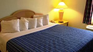 a bed with two pillows and a night stand at Cocoa Beach Suites Hotel in Cocoa Beach
