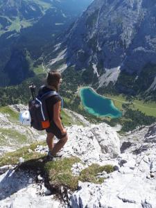eine Person mit einem Rucksack auf einem Berg in der Unterkunft Tirolerhof in Lermoos