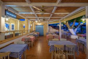 un ristorante con tavoli e sedie blu e bianchi di Mythos Suites Hotel a Tigaki