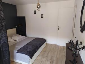 um quarto com uma cama e uma cruz na parede em "Antre Nous" au Cœur de Lunel em Lunel