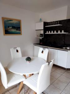 een witte tafel en stoelen in een keuken bij Apartments Beba Zalad in Sutomore