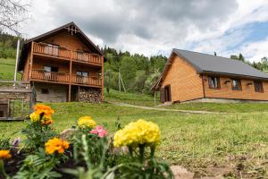 a wooden house with flowers in front of it at Villa Grace in Oryavchyk