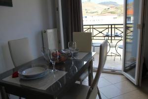 una mesa con copas de vino y un balcón en Myrina View 2, en Mirina