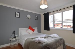 a bedroom with a bed with red and white pillows at Central 2 Bed 2 Bath Flat with Parking by CozyNest in Reading