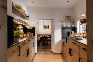 a kitchen with wooden cabinets and a dining room at Garni Hotel Tauber in Bressanone